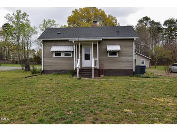 Charming single-story home featuring a covered front porch and a well-maintained lawn at 312 W Steele St, Gibsonville, NC 27249