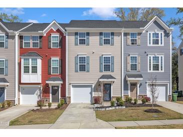 Charming townhouse exterior with colorful siding, attached garage, and well-maintained landscaping at 404 Cotton Brook Dr, Fuquay Varina, NC 27526