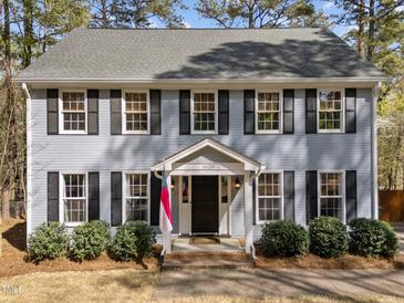 Charming two-story home with black shutters, gray siding, and well-manicured landscaping at 5120 Knaresborough Rd, Raleigh, NC 27612