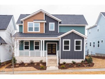 Charming two-story home with a stylish front porch and professionally landscaped yard at 555 Vine Pkwy, Pittsboro, NC 27312