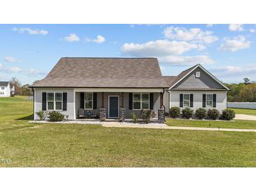 Charming single-story home featuring a welcoming porch, stone-accented posts, and beautiful landscaping at 676 Wall Rd, Wendell, NC 27591
