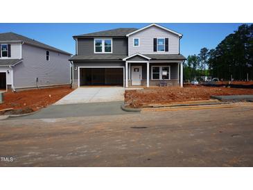 New two-story home featuring a two-car garage, gray siding, and a well-manicured front yard at 700 Deschutes Dr, Garner, NC 27529