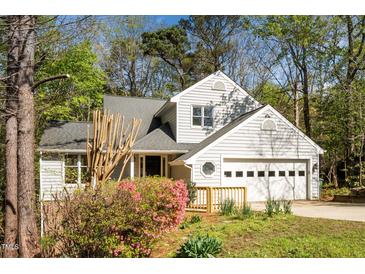 Charming two-story home with a well-maintained lawn, attached garage, and blooming azaleas at 124 Ripley Ct, Cary, NC 27513