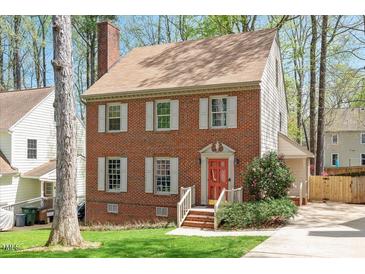 Charming two-story brick home featuring white shutters and a vibrant red front door at 202 Lighthouse Way, Cary, NC 27511