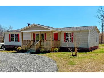 Inviting single-story home with a charming front porch, red accents, and well-maintained landscaping at 210 Holloway Rd, Roxboro, NC 27573