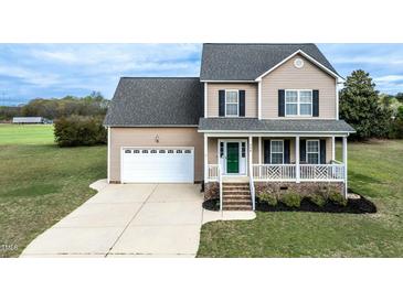 Charming two-story home featuring a cozy front porch, attached garage, and well-manicured lawn at 236 Summer Place Ct, Clayton, NC 27527
