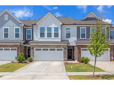 Charming townhomes featuring brick accents, attached garages, and beautifully landscaped front yards, offering modern living in a vibrant community at 242 Luftee Ln, Holly Springs, NC 27540