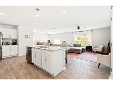 Bright, open floor plan featuring a kitchen island flowing into the living area, perfect for modern living at 2512 Lily Dr, Haw River, NC 27258