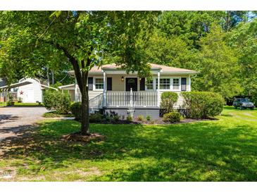 Charming one-story home featuring a welcoming front porch and beautifully landscaped front yard with lush greenery at 2616 Bullock Rd, Durham, NC 27704