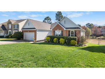 Charming home with brick accents, attached garage, well-manicured lawn and mature landscaping at 406 Southshore Pkwy, Durham, NC 27703