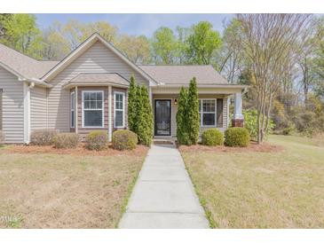 Charming home featuring a well-manicured lawn and inviting walkway to the front door at 469 Winding Wood Dr, Clayton, NC 27520