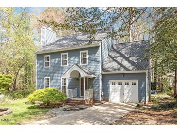 Charming two-story home featuring a well-manicured lawn and attached garage, painted in light blue at 4725 Sinclair Dr, Raleigh, NC 27616