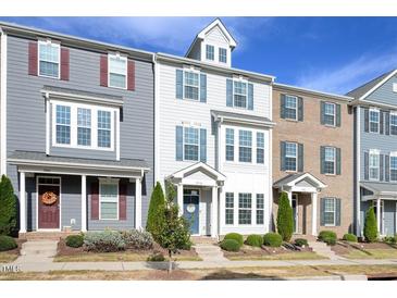 Charming townhome exterior featuring blue shutters and a well-manicured lawn, offering curb appeal at 5918 Giddings St, Raleigh, NC 27616