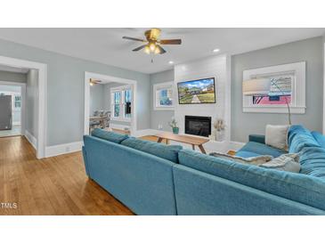Inviting living room with a fireplace, hardwood floors, and a comfortable blue sofa at 602 Dunbar St, Durham, NC 27701