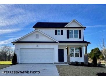 Charming two-story home with attached garage, a manicured lawn, and appealing architectural details at 61 Fetterbush Way, Clayton, NC 27520