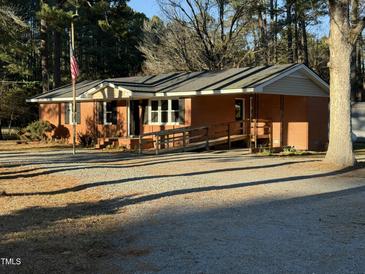 Charming one-story brick home featuring a ramp, an American flag and a gravel driveway at 640 Crocker Rd, Smithfield, NC 27577