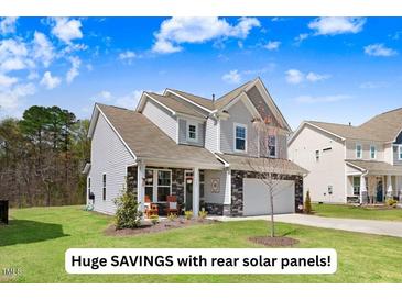 Charming two-story home with a well-manicured lawn and inviting front porch at 825 Golden Plum Ln, Zebulon, NC 27597