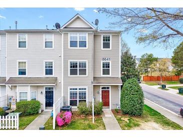 Inviting townhome with neutral siding, blooming azaleas, and a charming red front door at 8641 Neuse Club Ln # 110, Raleigh, NC 27616