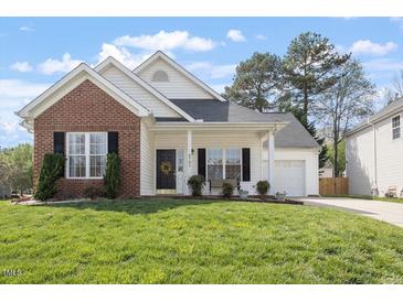 Charming home with a brick accent, covered front porch, and well-maintained lawn at 8701 Neuse Village Ct, Raleigh, NC 27616