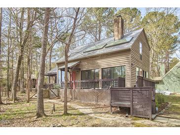 Charming home featuring wood siding, a cozy front porch, and a surrounding forest setting at 103 Morningside Dr, Carrboro, NC 27510