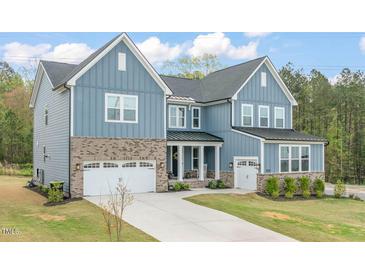 Charming two-story home with a well-manicured lawn and a three-car garage, enhanced by brick and siding accents at 1121 White Oak Creek Dr, Apex, NC 27523