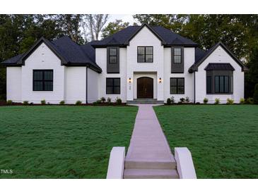 Stunning two-story home with a manicured lawn and a beautiful walkway leading to the front door at 186 Evington Dr, Pittsboro, NC 27312