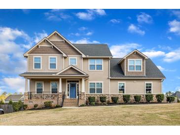 Beautiful two-story home featuring a well-manicured lawn, stone accents, and a welcoming front porch at 208 Tarkenton Ct, Clayton, NC 27527