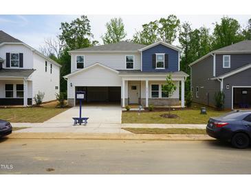 Charming two-story home featuring a welcoming front porch and open garage at 2118 Cherry Creek Rd, Haw River, NC 27258
