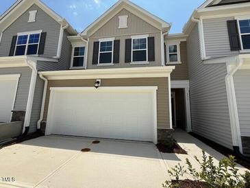 Charming home showcasing a two-car garage with driveway and tasteful exterior design at 237 Shingle Oak Rd, Wake Forest, NC 27587