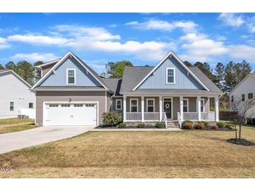 Charming two-story home with inviting front porch, two-car garage, and manicured lawn at 274 Ashpole Trl, Clayton, NC 27520