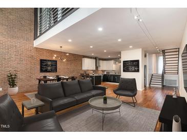 Open concept living room with exposed brick wall and modern furnishings at 4229 American Dr # F, Durham, NC 27705