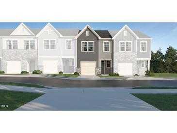 Charming townhome featuring a stone-accented garage and a welcoming front entrance at 804 Windmill Palm Dr, Zebulon, NC 27597