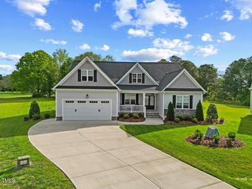 Charming single-Gathering home with a well-manicured lawn, attached two-car garage and inviting front porch at 8925 Hopkins Knob Ct, Zebulon, NC 27597