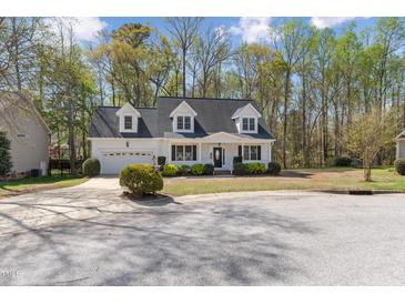 Charming white home featuring dormer windows, a front porch, and a well-manicured front yard at 912 Sethcreek Dr, Fuquay Varina, NC 27526