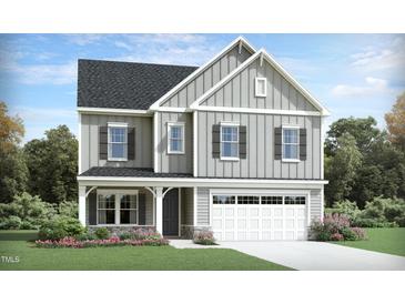 Charming two-story home featuring a two-car garage, landscaped front yard, and stylish board and batten siding at 929 Thimbleweed Way, Wake Forest, NC 27587