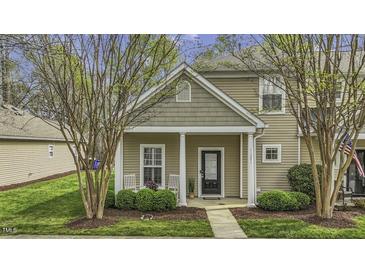 Inviting two-story home featuring a charming front porch with manicured landscaping at 11251 Lofty Heights Pl, Raleigh, NC 27614