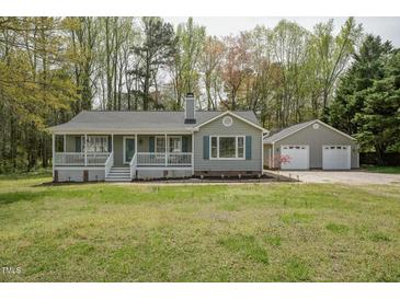 Charming single-story home with a welcoming front porch, detached two-car garage, and well-manicured lawn at 114 Marshay Meadow Rd, Youngsville, NC 27596