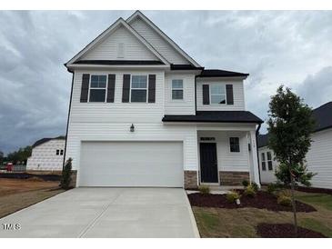 Charming two-story home features a two-car garage and a well-maintained lawn at 118 Fairwinds Drive Dr, Lillington, NC 27546