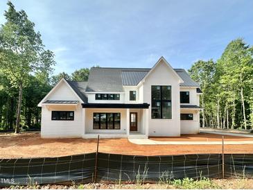 Stunning new construction home with modern black trim, board and batten siding, and a metal roof at 1309 Sanctuary Pond Dr, Raleigh, NC 27603