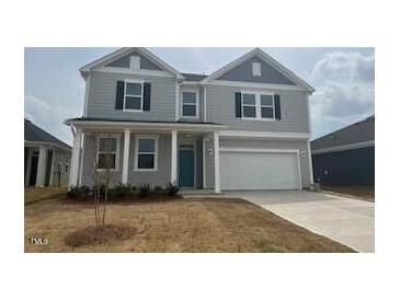Charming two-story home featuring a welcoming front porch and two-car garage at 190 Chestnut Oak Ln, Lillington, NC 27546