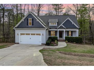 Charming single-Gathering home features a two-car garage, mature trees, and manicured lawn at 191 W Cultivator Way, Clayton, NC 27520