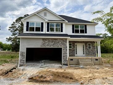 New two story home featuring white siding, black shutters, stone accents and an attached two car garage at 193 Falls Of The Cape Dr, Lillington, NC 27546