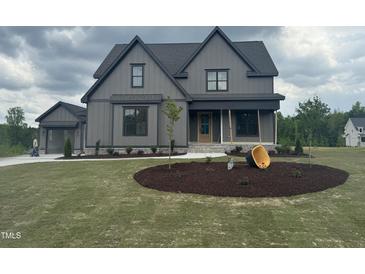 Beautifully designed two-story home with a gray facade, manicured lawn, and tasteful landscaping at 20 Serenity Woods Trl, Franklinton, NC 27525