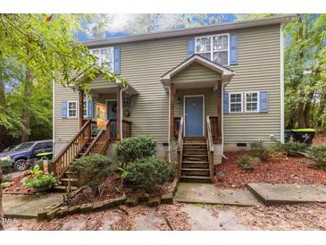 Charming duplex with light green siding, wood stairs, blue shutters, and well-maintained landscaping at 209 Mill St # A/B, Creedmoor, NC 27522