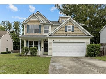Charming two-story home featuring a two-car garage, well-manicured lawn, and inviting front porch at 2112 Queensway Ct, Creedmoor, NC 27522