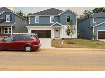 Charming two-story home with blue and white siding and an attached two-car garage at 2207 Cherry Creek Rd, Haw River, NC 27258