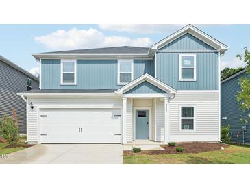 Charming two-story home featuring a two-car garage, blue and white siding, and manicured landscaping at 2207 Cherry Creek Rd, Haw River, NC 27258
