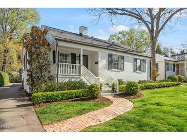 Charming home with a brick walkway leading to a covered front porch and well-manicured landscaping at 2714 Gordon St, Raleigh, NC 27608