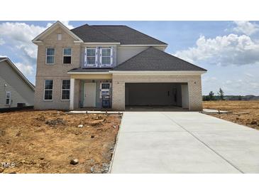 Under construction, this two-story brick home features an attached garage and a long concrete driveway at 2719 Lacy Holt Rd, Graham, NC 27253