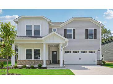 Charming two-story home featuring a covered porch, two-car garage, and a beautifully landscaped front yard at 3849 Rosebush Dr, Zebulon, NC 27597